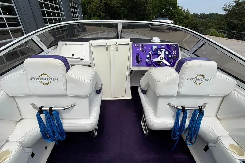 Slide: The Image of 2003 Fountain 29 Fever boat interior with white seats, purple dashboard, and blue ropes. - 11