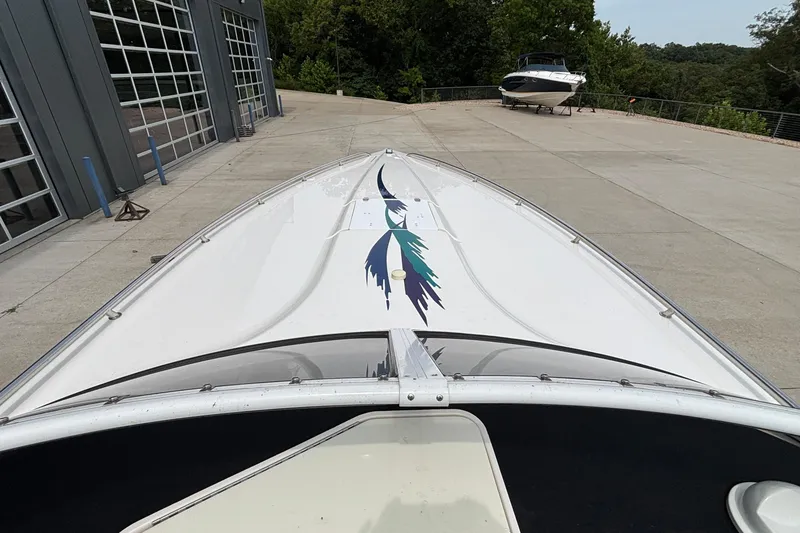 Slide: The Image of 2003 Fountain 29 Fever boat with colorful graphics, parked near a garage. - 12