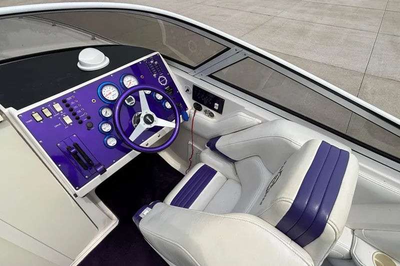 Slide: The Image of 2003 Fountain 29 Fever boat cockpit with purple dashboard and white seating. - 17