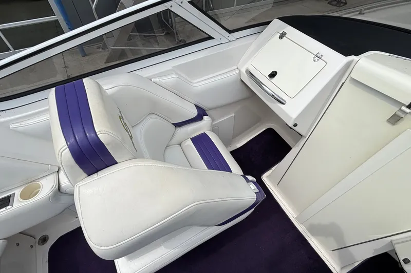 Slide: The Image of 2003 Fountain 29 Fever boat interior with white and purple seating, dashboard, and storage compartment. - 19