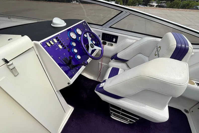 Slide: The Image of Interior of a 2003 Fountain 29 Fever boat with purple dashboard and white seats. - 21