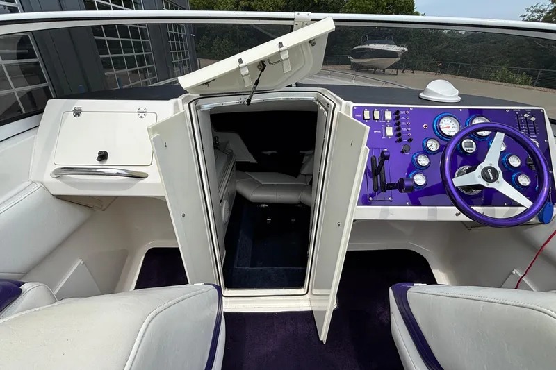 Slide: The Image of 2003 Fountain 29 Fever boat cockpit with purple dashboard and open cabin door. - 22