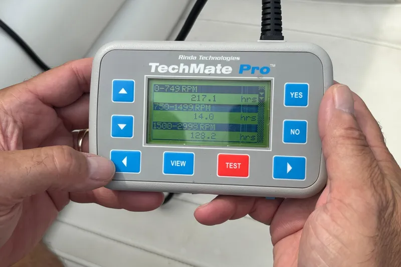 Slide: The Image of Hands holding TechMate Pro diagnostic tool displaying RPM data for 2003 Fountain 29 Fever boat. - 32