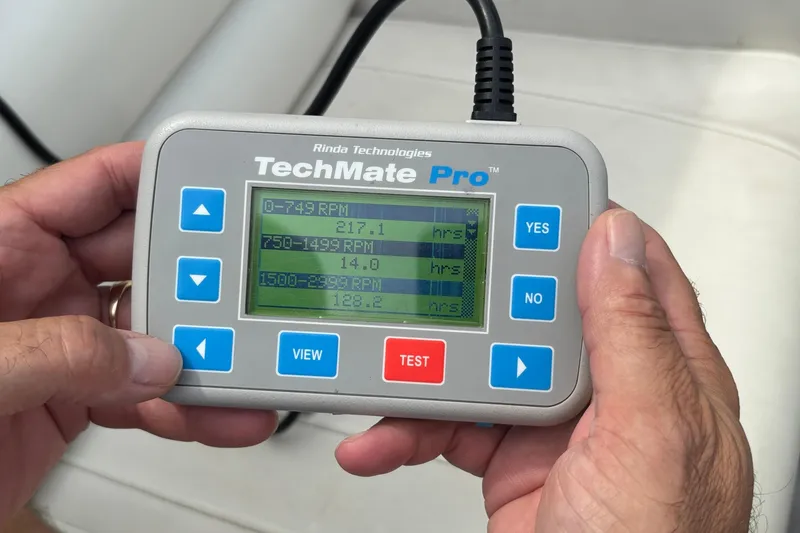 Slide: The Image of Hands holding a TechMate Pro diagnostic tool displaying RPM data for a 2003 Fountain 29 Fever boat. - 33