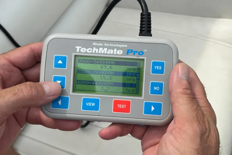 Slide: The Image of Hands holding TechMate Pro diagnostic tool displaying RPM hours for Fountain 29 Fever boat. - 34