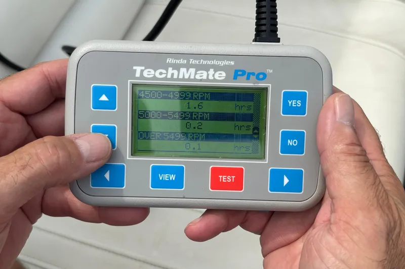 Slide: The Image of Hand holding TechMate Pro diagnostic tool displaying RPM data for 2003 Fountain 29 Fever. - 35