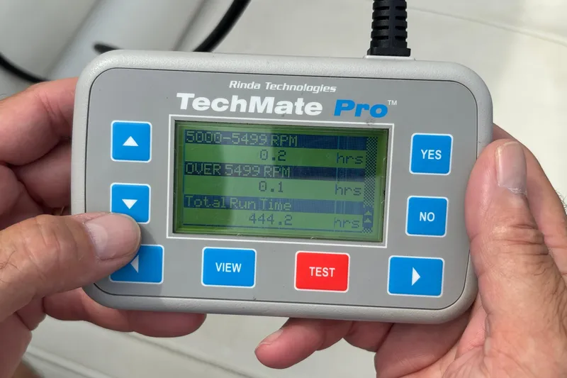 Slide: The Image of Hand holding TechMate Pro diagnostic tool displaying engine run time data. - 36