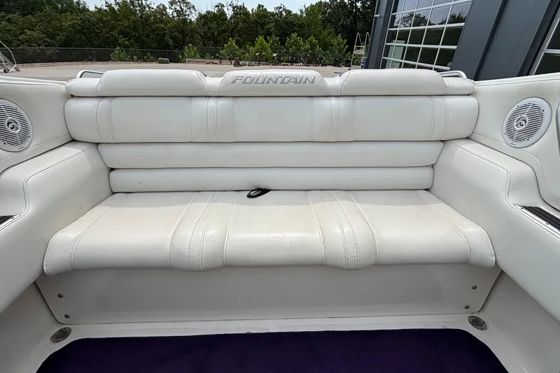 Slide: The Image of White leather seating on a 2003 Fountain 29 Fever boat, featuring built-in speakers. - 8
