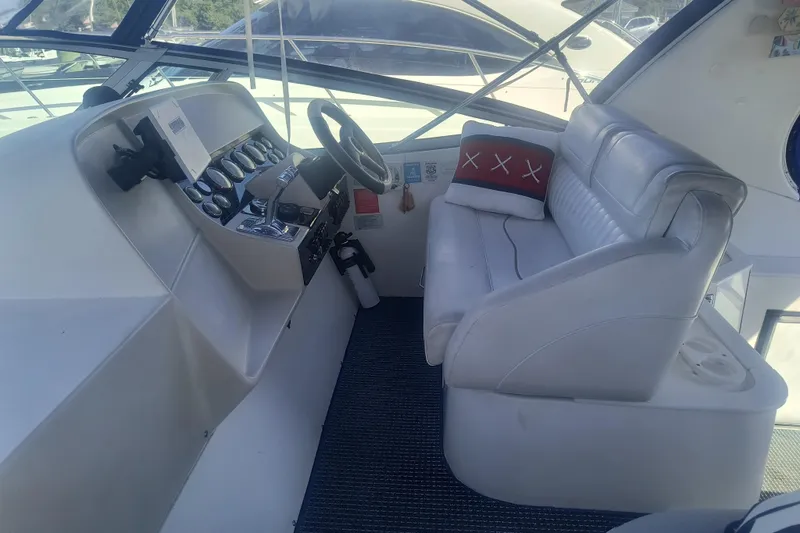 Slide: The Image of 2000 Cruisers Yachts 3575 Express helm with white seating and control panel. - 16