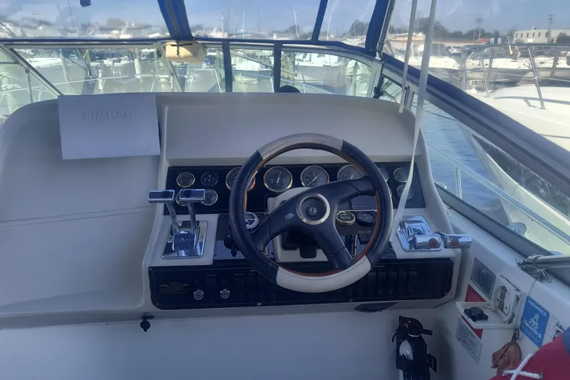 Slide: The Image of 2000 Cruisers Yachts 3575 Express helm with steering wheel and control panel. - 17