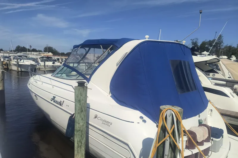 Slide: The Image of 2000 Cruisers Yachts 3575 Express docked, featuring blue canopy and sleek design. - 12