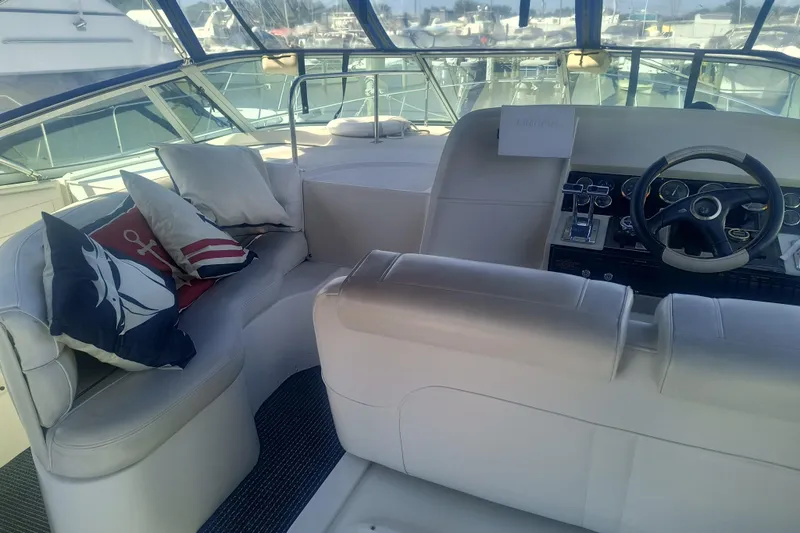 Slide: The Image of 2000 Cruisers Yachts 3575 Express interior with helm and cushioned seating area. - 14