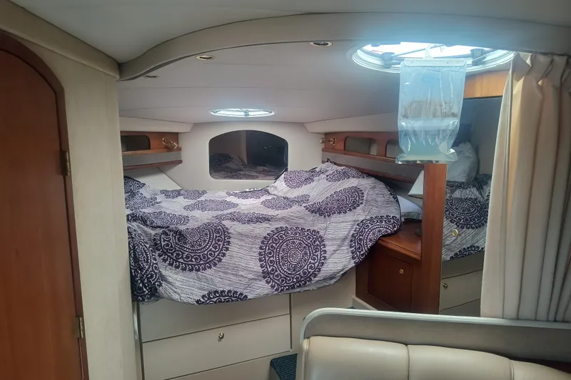 Slide: The Image of Interior cabin of 2000 Cruisers Yachts 3575 Express with patterned bedding and wooden accents. - 23