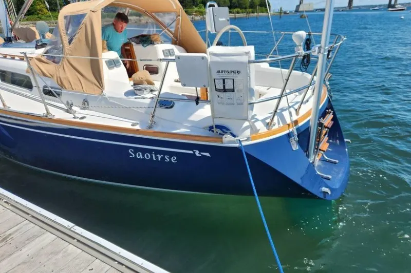 Slide: The Image of 2002 Sabre 362 sailboat "Saoirse" docked, featuring blue hull and tan canopy. - 9