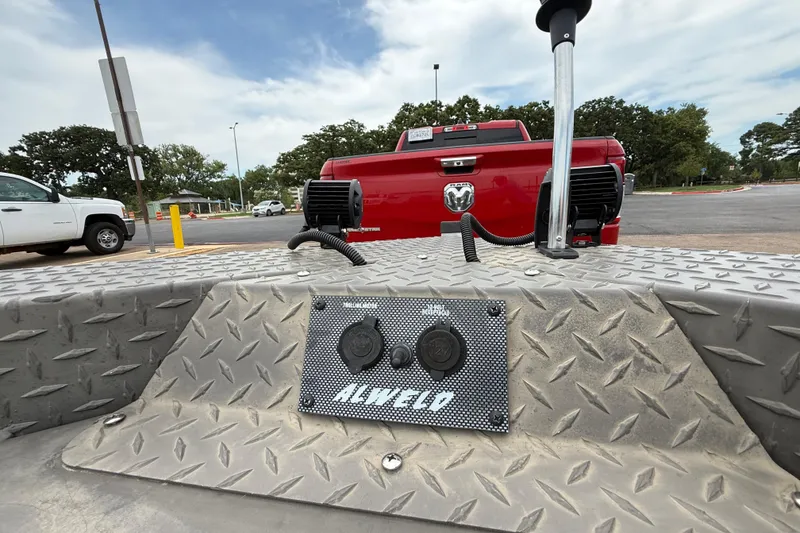 Slide: The Image of 2021 Alweld 1852 Invader boat with diamond plate flooring, parked near a red truck. - 23