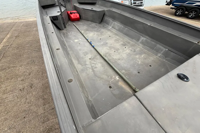 Slide: The Image of 2021 Alweld 1852 Invader boat interior with storage and fuel tank, near water. - 24