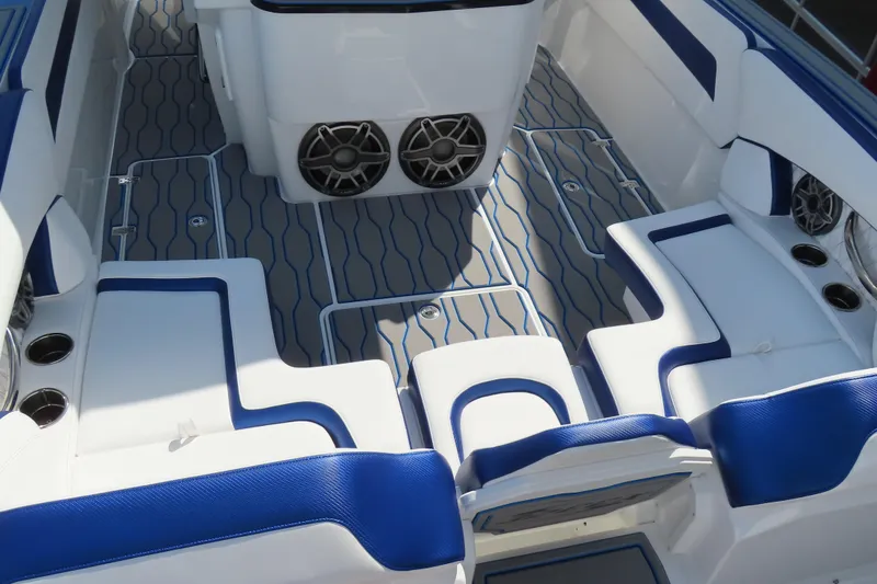 Slide: The Image of 2026 Sunsation 32CCX boat interior with blue and white seating, modern design, and speakers. - 12