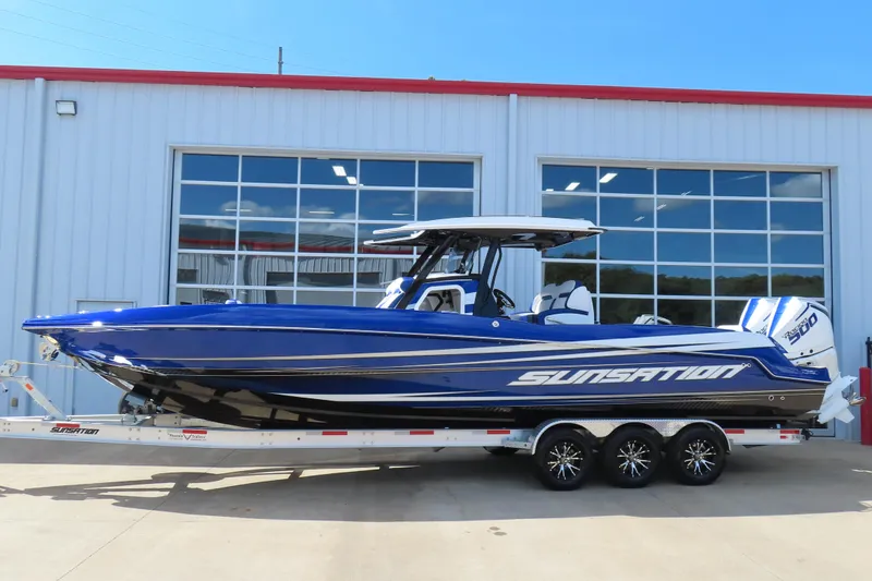 Slide: The Image of 2026 Sunsation 32CCX boat in blue, parked on a trailer outside a building. - 26