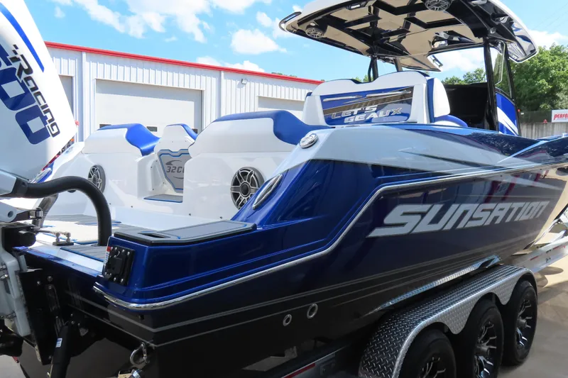 Slide: The Image of 2026 Sunsation 32CCX boat with sleek blue design and powerful engine, parked outdoors. - 5