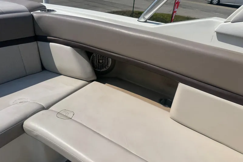 Slide: The Image of Interior seating of a 2011 Sea Ray 270 SLX boat, featuring beige upholstery. - 2