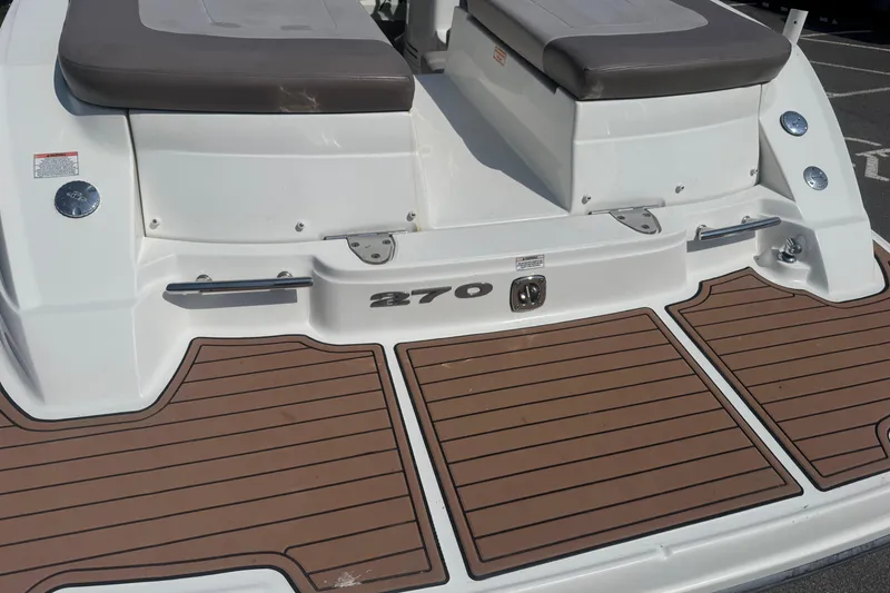 Slide: The Image of 2011 Sea Ray 270 SLX boat deck with brown teak-style flooring and cushioned seating. - 24