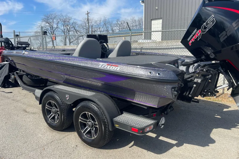 Slide: The Image of 2023 Triton 19TRX Patriot boat with dual-axle trailer, parked outdoors. - 5