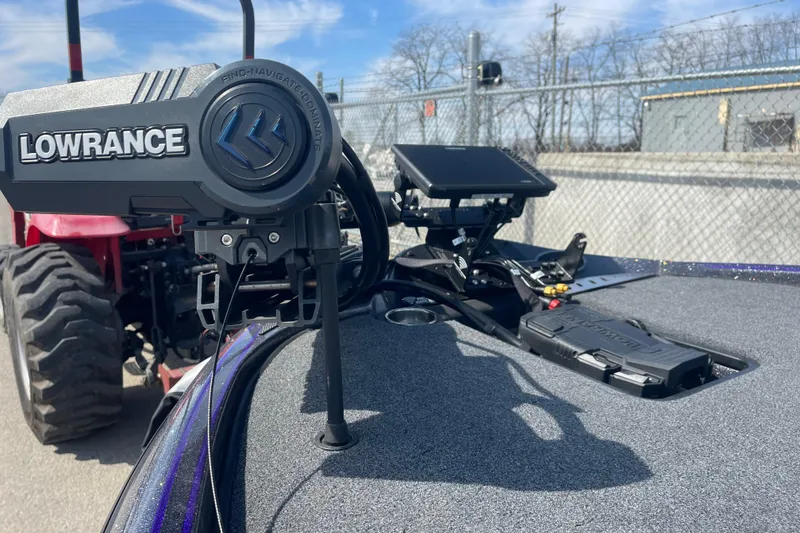 Slide: The Image of 2023 Triton 19TRX Patriot boat with Lowrance navigation system, parked near a red tractor. - 8