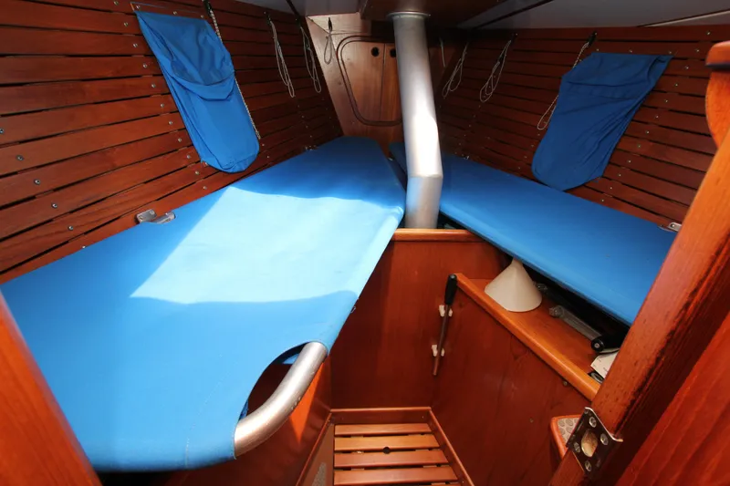 Slide: The Image of Interior cabin of 1982 Nautor Swan 371 sailboat with blue bunks and wooden paneling. - 16