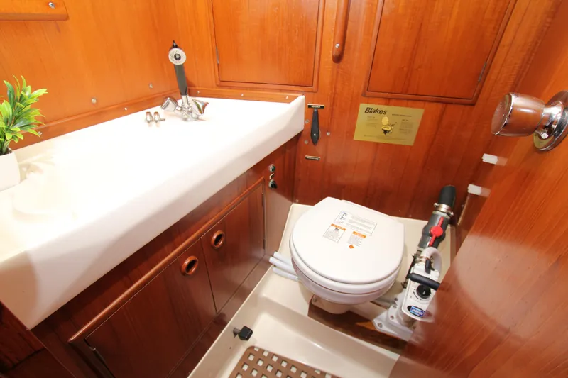 Slide: The Image of Nautor Swan 371 yacht bathroom, featuring wooden cabinetry and compact marine toilet. - 17