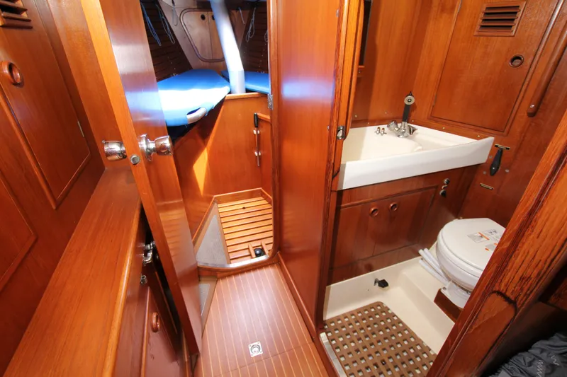 Slide: The Image of Interior of 1982 Nautor Swan 371 yacht, featuring wooden cabinetry, sink, and toilet. - 18