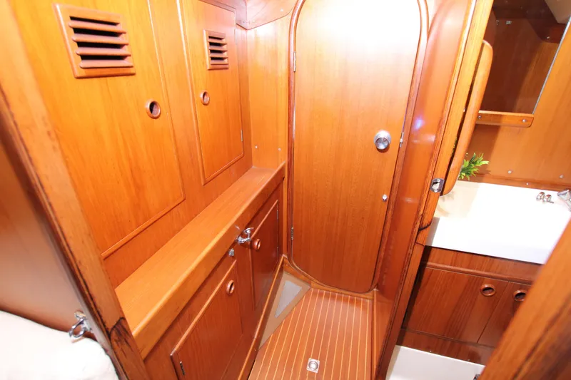 Slide: The Image of Interior of 1982 Nautor Swan 371 yacht, featuring wooden cabinetry and compact bathroom space. - 19
