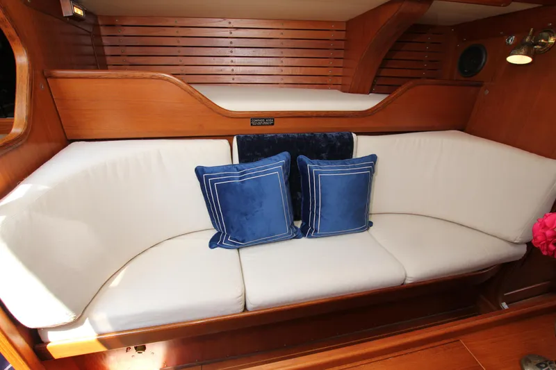 Slide: The Image of Interior of 1982 Nautor Swan 371 yacht with white seating and blue cushions. - 24