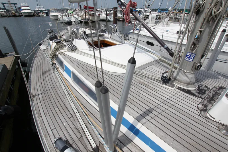 Slide: The Image of 1982 Nautor Swan 371 sailboat docked in a marina, showcasing its teak deck and rigging. - 7