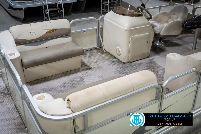 Slide: The Image of 2004 Bennington 185L pontoon boat interior with beige seating and steering console. - 11