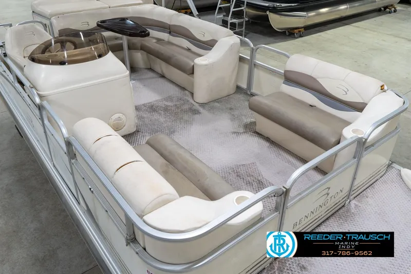 Slide: The Image of 2004 Bennington 185L pontoon boat with spacious seating and helm, displayed indoors. - 12