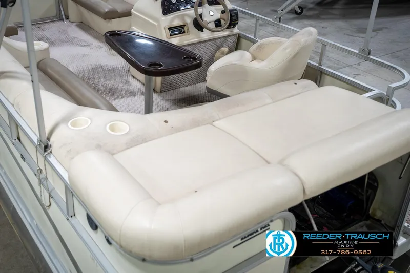 Slide: The Image of 2004 Bennington 185L pontoon boat interior with beige seating and steering console. - 14