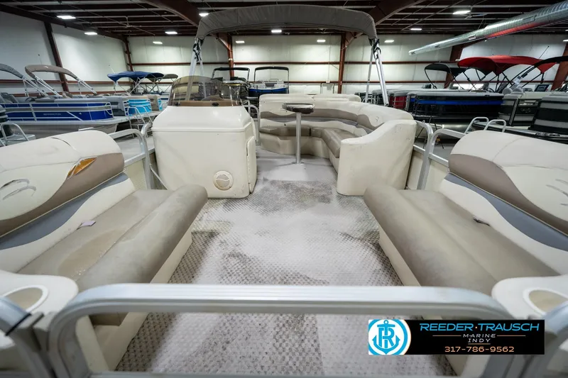 Slide: The Image of 2004 Bennington 185L pontoon boat interior with seating and helm, displayed indoors. - 15