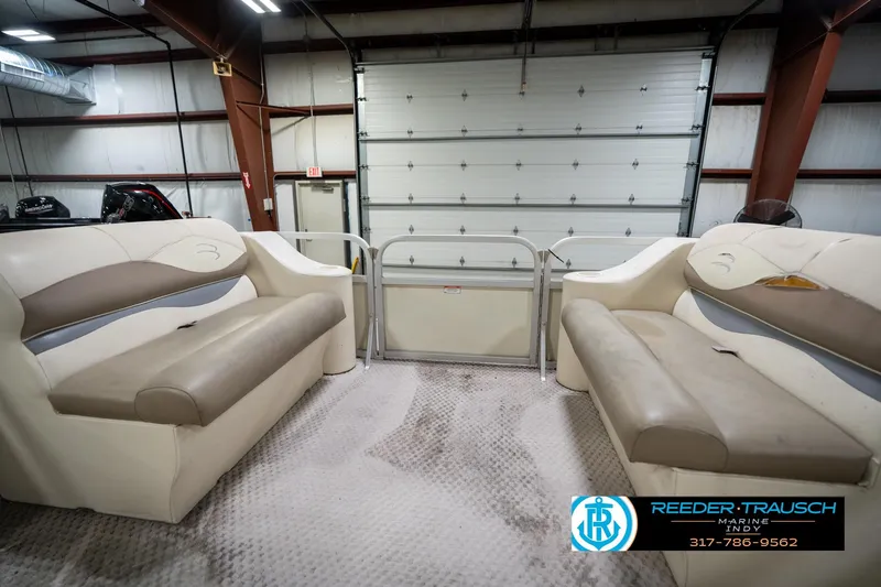 Slide: The Image of Interior of a 2004 Bennington 185L pontoon boat with beige seating in a garage. - 18