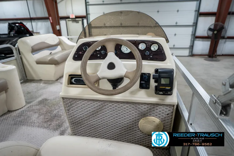 Slide: The Image of Steering console of a 2004 Bennington 185L pontoon boat in a garage setting. - 25
