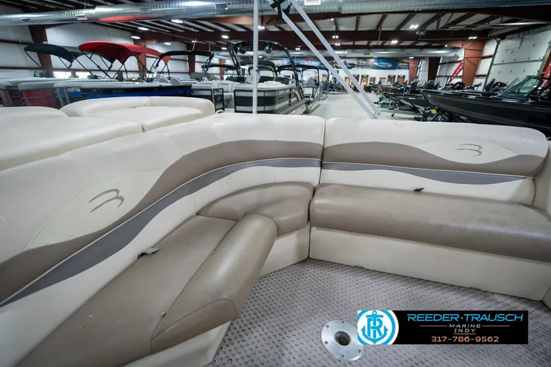 Slide: The Image of 2004 Bennington 185L pontoon boat interior with beige seating in a showroom. - 35
