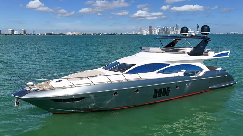 Slide: The Image of 2012 Azimut Flybridge yacht cruising on open water with city skyline backdrop. - 16