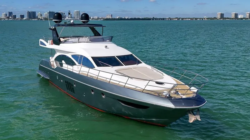 Slide: The Image of Azimut Flybridge 2012 yacht cruising on clear blue water with city skyline in background. - 4