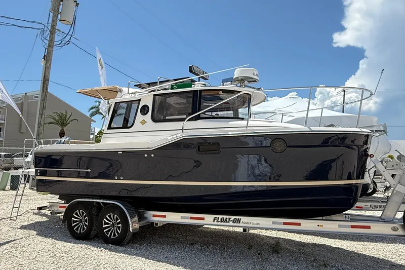 Slide: The Image of 2025 Ranger Tugs R-23 boat on trailer under clear blue sky. - 1