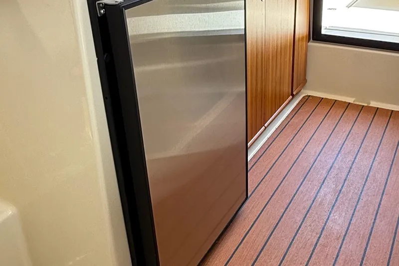 Slide: The Image of Interior of 2025 Ranger Tugs R-23 featuring a sleek stainless steel refrigerator. - 33