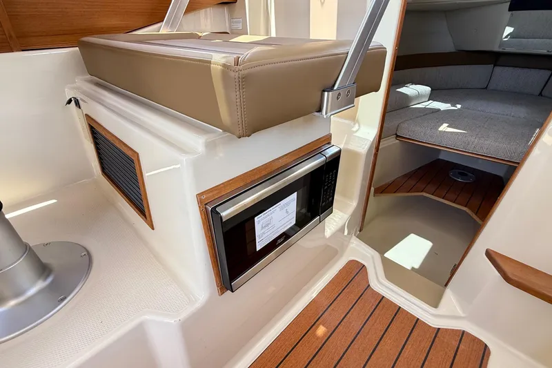 Slide: The Image of 2025 Ranger Tugs R-23 interior with microwave, seating, and cabin area. - 36