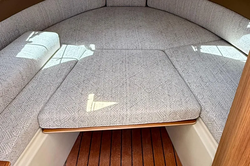 Slide: The Image of 2025 Ranger Tugs R-23 interior cabin with patterned cushions and wooden flooring. - 41