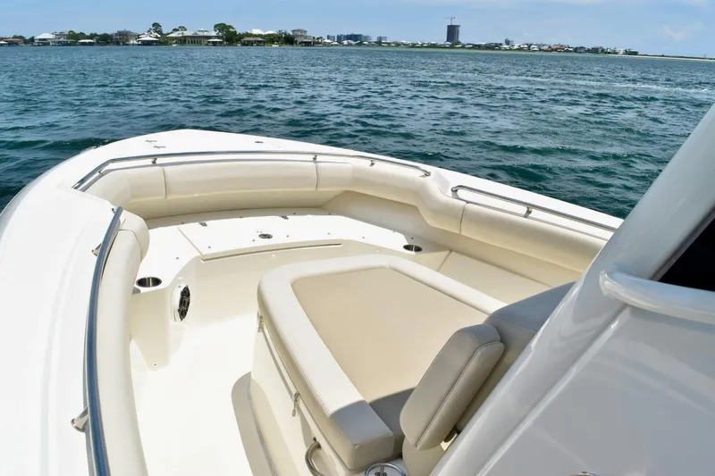 Slide: The Image of 2023 Boston Whaler 280 Outrage boat interior with cushioned seating on open water. - 10