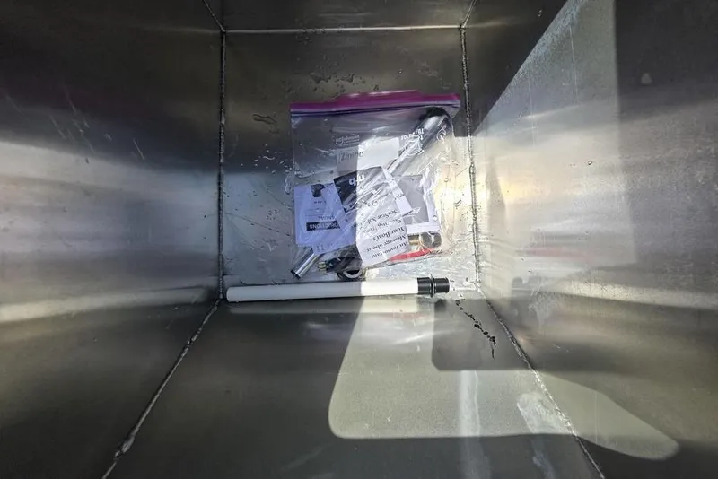 Slide: The Image of Interior of Weldcraft 1648 UV/DD ECONO Bass boat, showing storage compartment with accessories. - 14