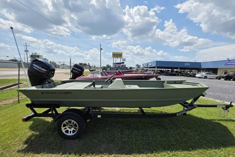 Slide: The Image of 2026 Weldcraft 1648 UV/DD ECONO Bass boat on trailer, parked outdoors under a cloudy sky. - 30