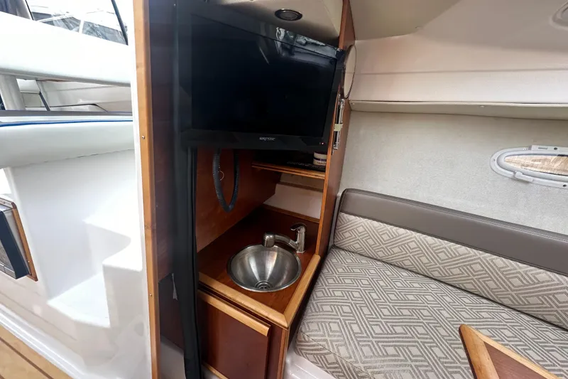 Slide: The Image of 2017 Cutwater C24 interior with TV, sink, and patterned seating. - 11